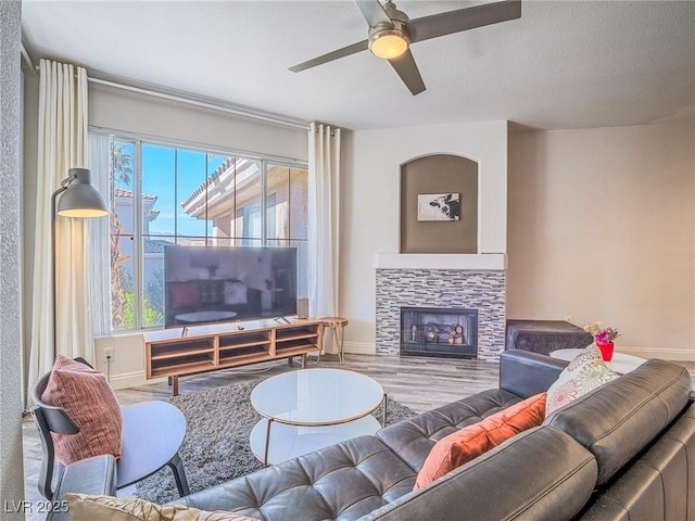 living area with a fireplace, wood finished floors, and baseboards