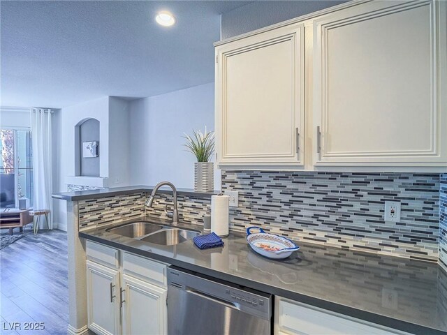 7111 S Durango Dr Unit 305, Las Vegas, NV 89113 - kitchen featuring dishwasher, decorative backsplash, wood finished floors, dark countertops, and a textured ceiling