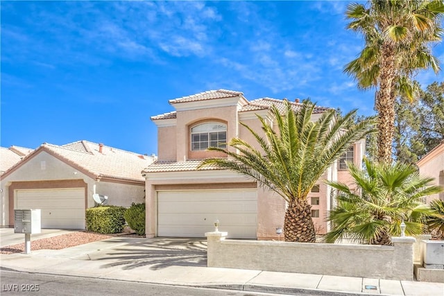 mediterranean / spanish-style house with stucco siding, concrete driveway, and a tiled roof