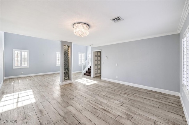 empty room featuring baseboards, visible vents, light wood-style flooring, stairs, and a notable chandelier