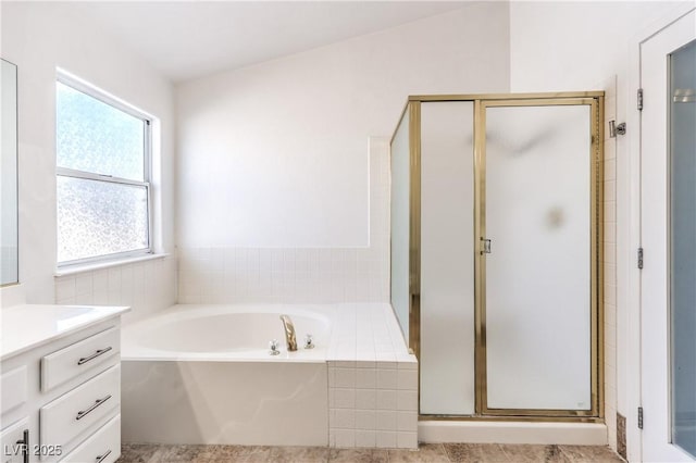 bathroom featuring a garden tub, vanity, and a shower stall