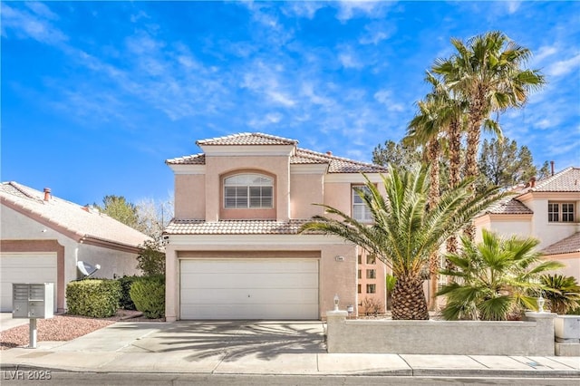 mediterranean / spanish-style house featuring concrete driveway, a tile roof, an attached garage, and stucco siding