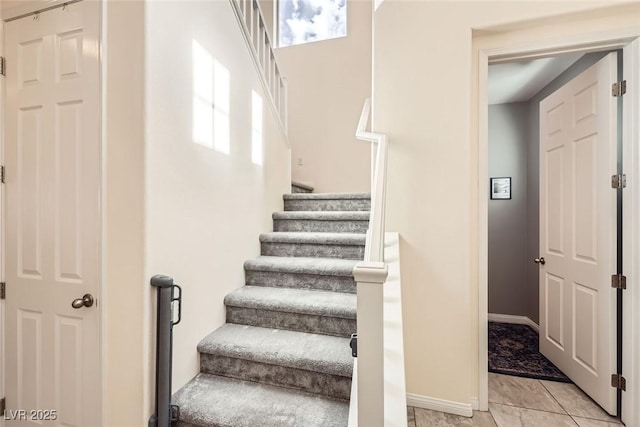 stairway featuring tile patterned flooring and baseboards