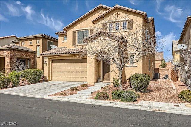 mediterranean / spanish house with driveway, a tiled roof, an attached garage, and stucco siding