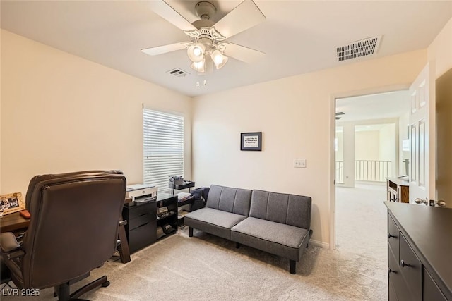 office area featuring light carpet, visible vents, and a ceiling fan