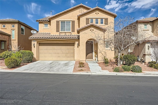 mediterranean / spanish-style home with driveway, a tiled roof, a garage, and stucco siding