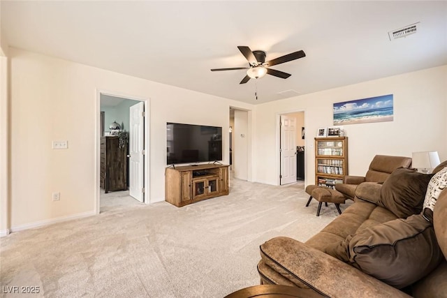 living room with a ceiling fan, light colored carpet, visible vents, and baseboards