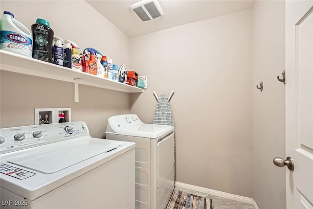 clothes washing area featuring washing machine and dryer, laundry area, visible vents, and baseboards