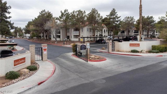 view of street featuring sidewalks, a gated entry, and curbs