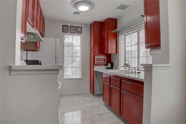 kitchen with visible vents, marble finish floor, light countertops, dark brown cabinets, and a sink