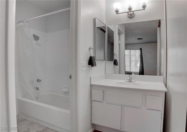 full bath with shower / tub combo, vanity, and a textured ceiling