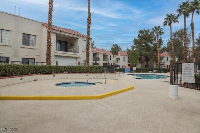 community pool featuring a residential view, fence, and a community hot tub