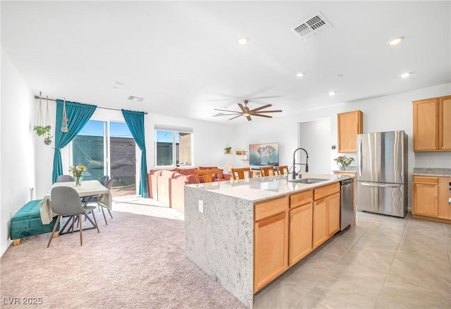 kitchen featuring visible vents, a kitchen island with sink, a sink, recessed lighting, and stainless steel appliances