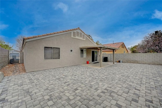 rear view of property featuring a patio area, a fenced backyard, and stucco siding