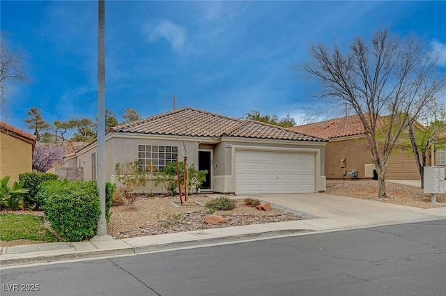 mediterranean / spanish house featuring a garage, driveway, a tiled roof, and stucco siding