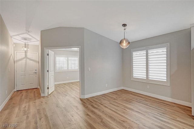 unfurnished room featuring light wood finished floors, visible vents, and baseboards