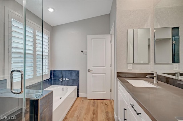 bathroom with lofted ceiling, wood finished floors, vanity, a shower stall, and a bath