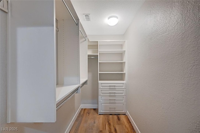 spacious closet featuring visible vents and light wood-style flooring