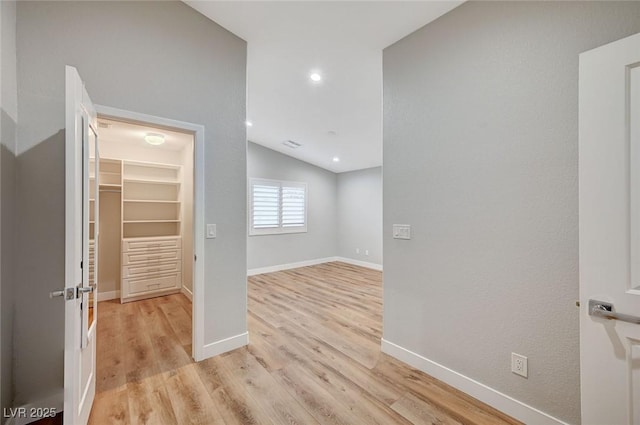 interior space featuring lofted ceiling, baseboards, light wood finished floors, and recessed lighting