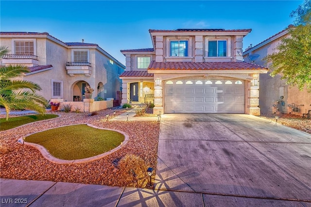 mediterranean / spanish-style home featuring a garage, driveway, a tiled roof, and stucco siding