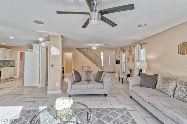 living area with ceiling fan, stairway, and recessed lighting