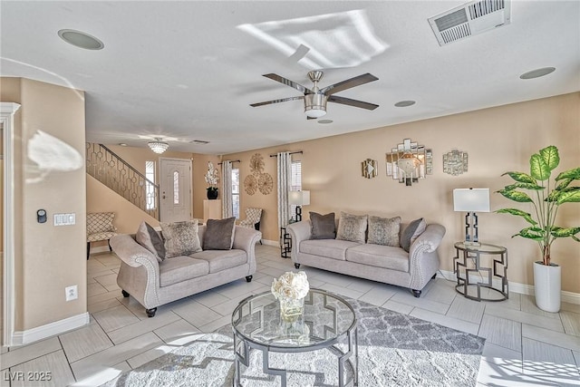 living area with ceiling fan, light tile patterned flooring, visible vents, baseboards, and stairs