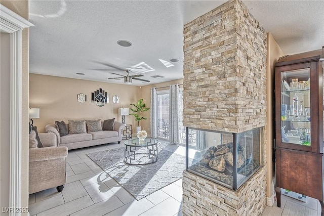 living room featuring a textured ceiling, visible vents, and a ceiling fan