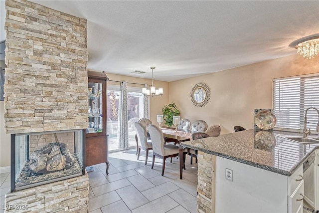 dining space featuring a chandelier, light tile patterned floors, a textured ceiling, and visible vents