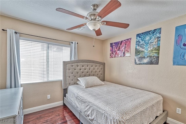 bedroom with dark wood-style floors, baseboards, a textured ceiling, and a textured wall