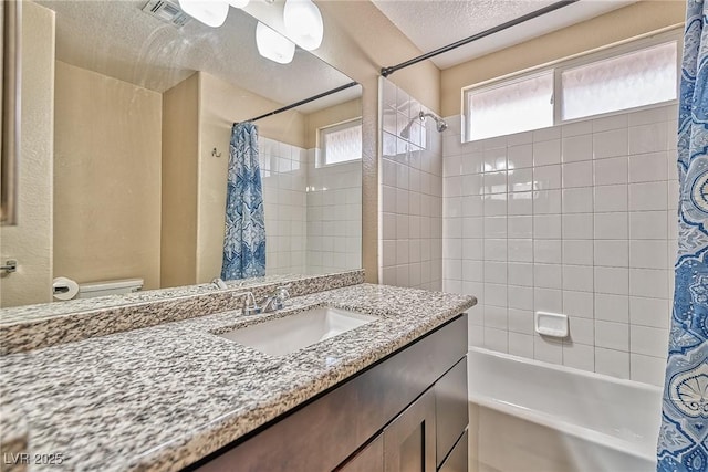 bathroom featuring visible vents, toilet, shower / bath combo with shower curtain, a textured ceiling, and vanity