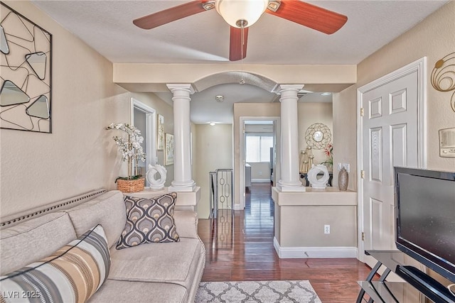 living area with ornate columns, baseboards, a ceiling fan, and wood finished floors