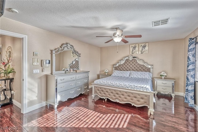 bedroom with baseboards, visible vents, ceiling fan, wood finished floors, and a textured ceiling