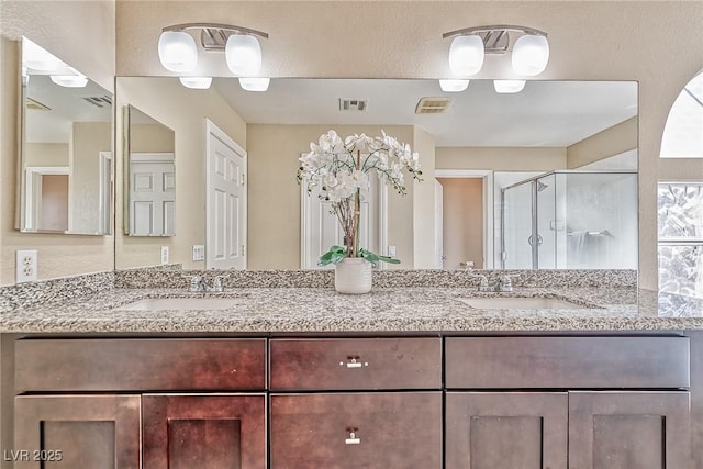 full bathroom with a stall shower, visible vents, and a sink