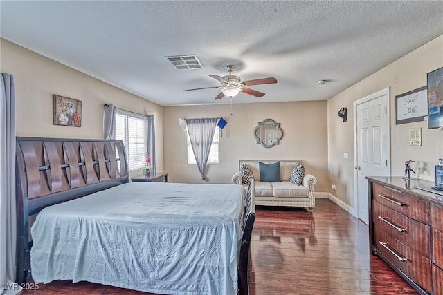 bedroom with dark wood-style floors, visible vents, a ceiling fan, a textured ceiling, and baseboards