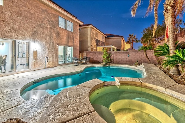 view of pool featuring a patio area, a fenced backyard, and a pool with connected hot tub