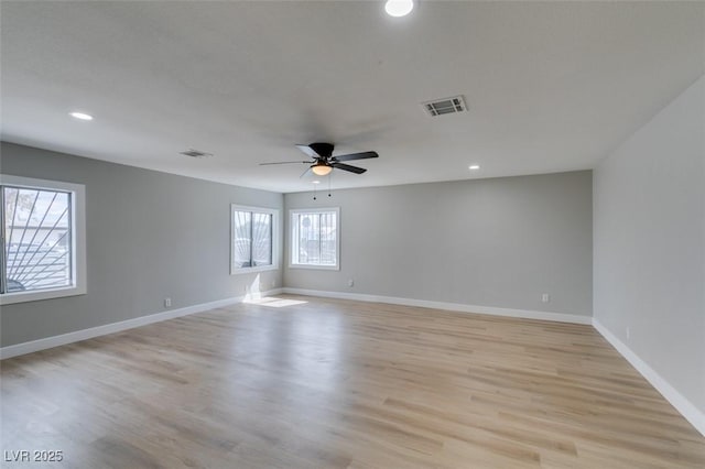 empty room featuring visible vents, baseboards, and light wood finished floors