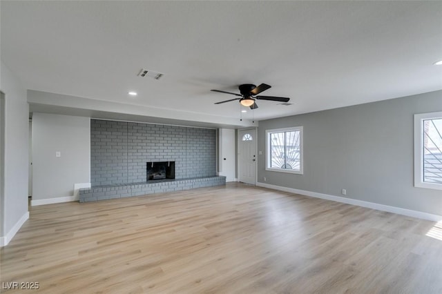 unfurnished living room featuring visible vents, a fireplace, light wood-type flooring, and baseboards