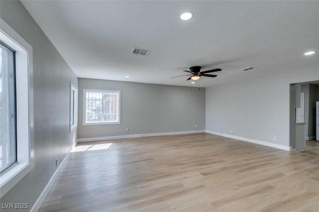 empty room featuring visible vents, baseboards, and light wood-style flooring