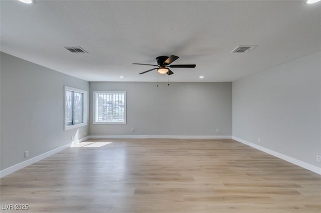 spare room with visible vents, baseboards, and light wood finished floors