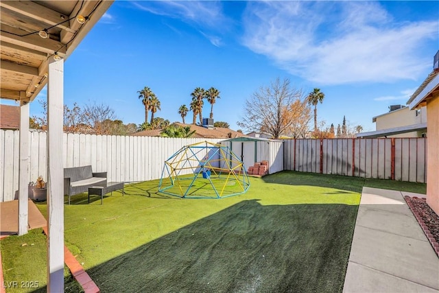 view of yard with a shed, a fenced backyard, and an outdoor structure