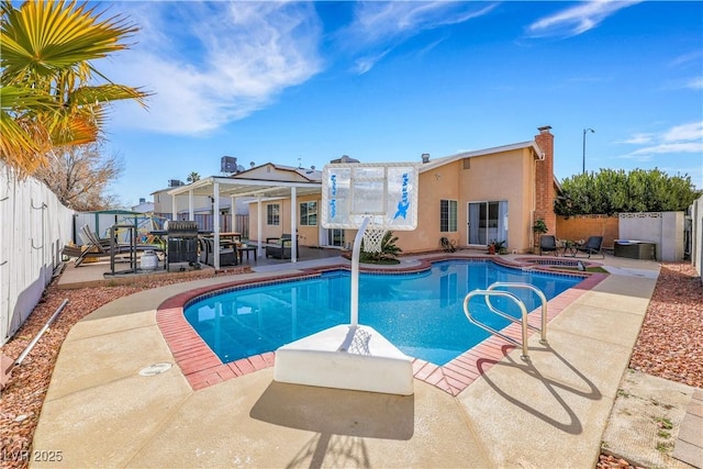 view of swimming pool featuring an in ground hot tub, a fenced backyard, a fenced in pool, and a patio