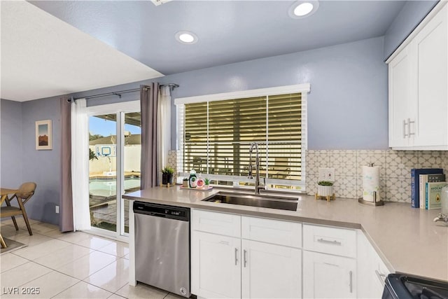 kitchen with light countertops, stainless steel dishwasher, a sink, and decorative backsplash