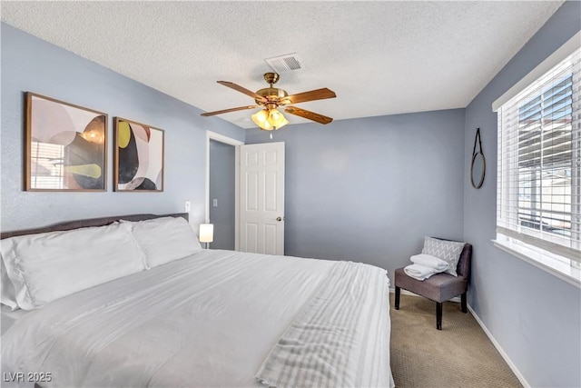 bedroom featuring a textured ceiling, ceiling fan, carpet flooring, and visible vents