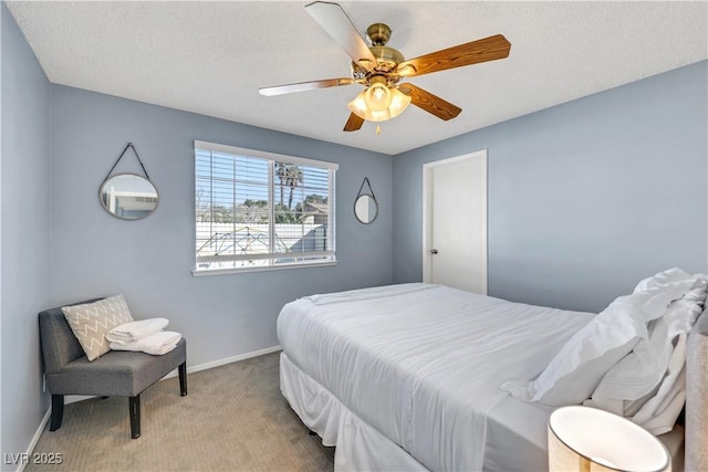 bedroom with ceiling fan, carpet floors, a textured ceiling, and baseboards