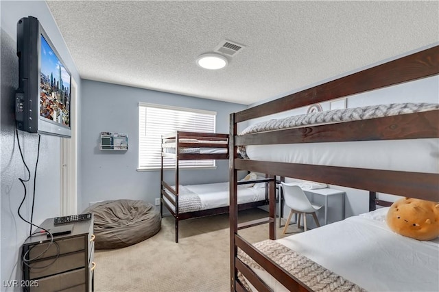 carpeted bedroom with visible vents and a textured ceiling