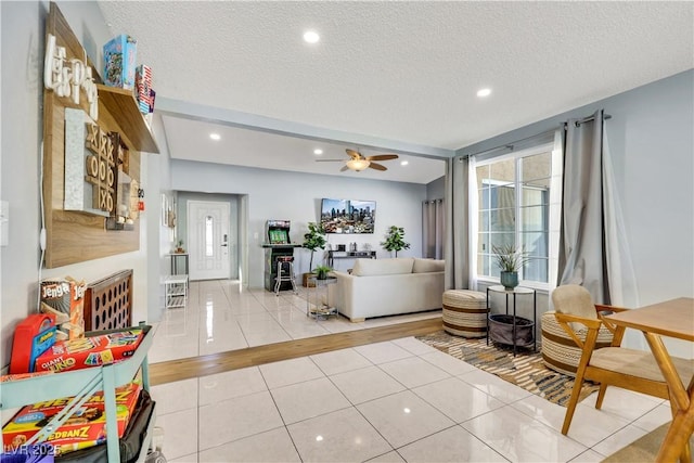 interior space with light tile patterned floors, a ceiling fan, a textured ceiling, and recessed lighting