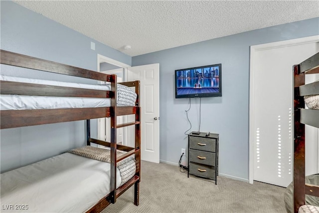 carpeted bedroom featuring a textured ceiling and baseboards