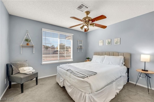 bedroom featuring a textured ceiling, carpet, visible vents, and baseboards