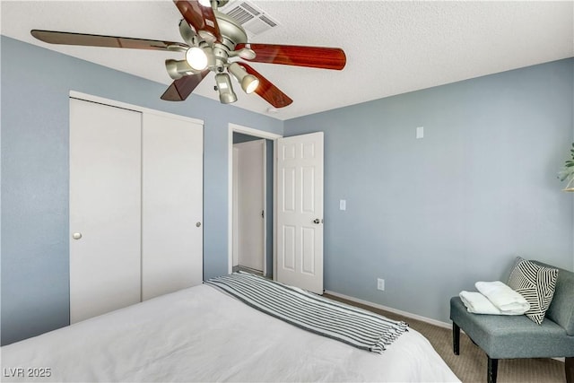 carpeted bedroom featuring baseboards, a closet, visible vents, and a ceiling fan