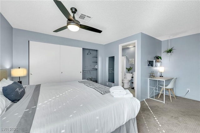 bedroom featuring carpet flooring, visible vents, and a textured ceiling